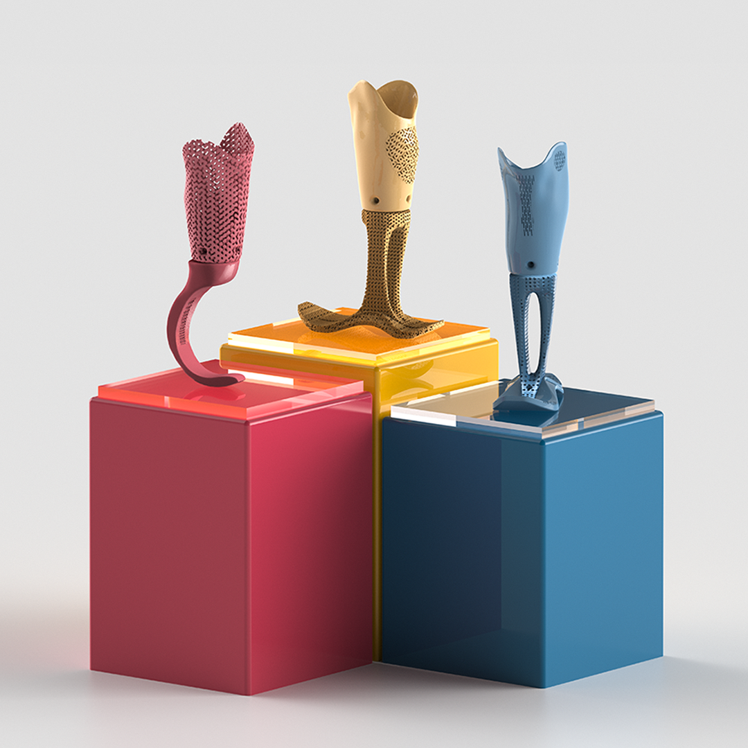 Three unique prosthetics sit on three colored cubes.